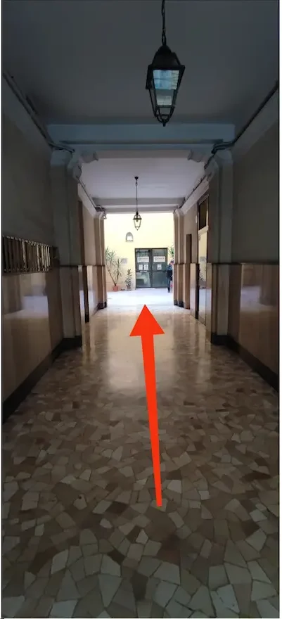 percorri il corridoio di accesso al cortile interno verso la scala c