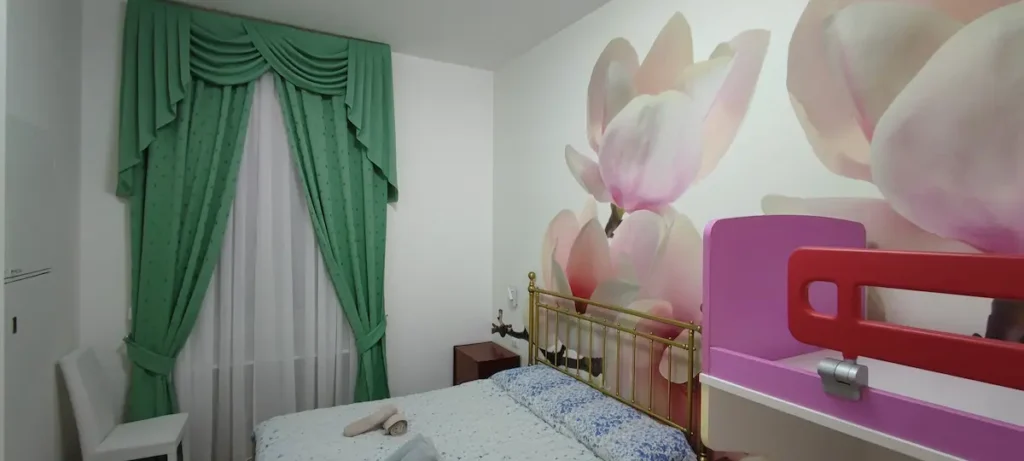 camera 1 magnolia vista con tende d'arredo e letti